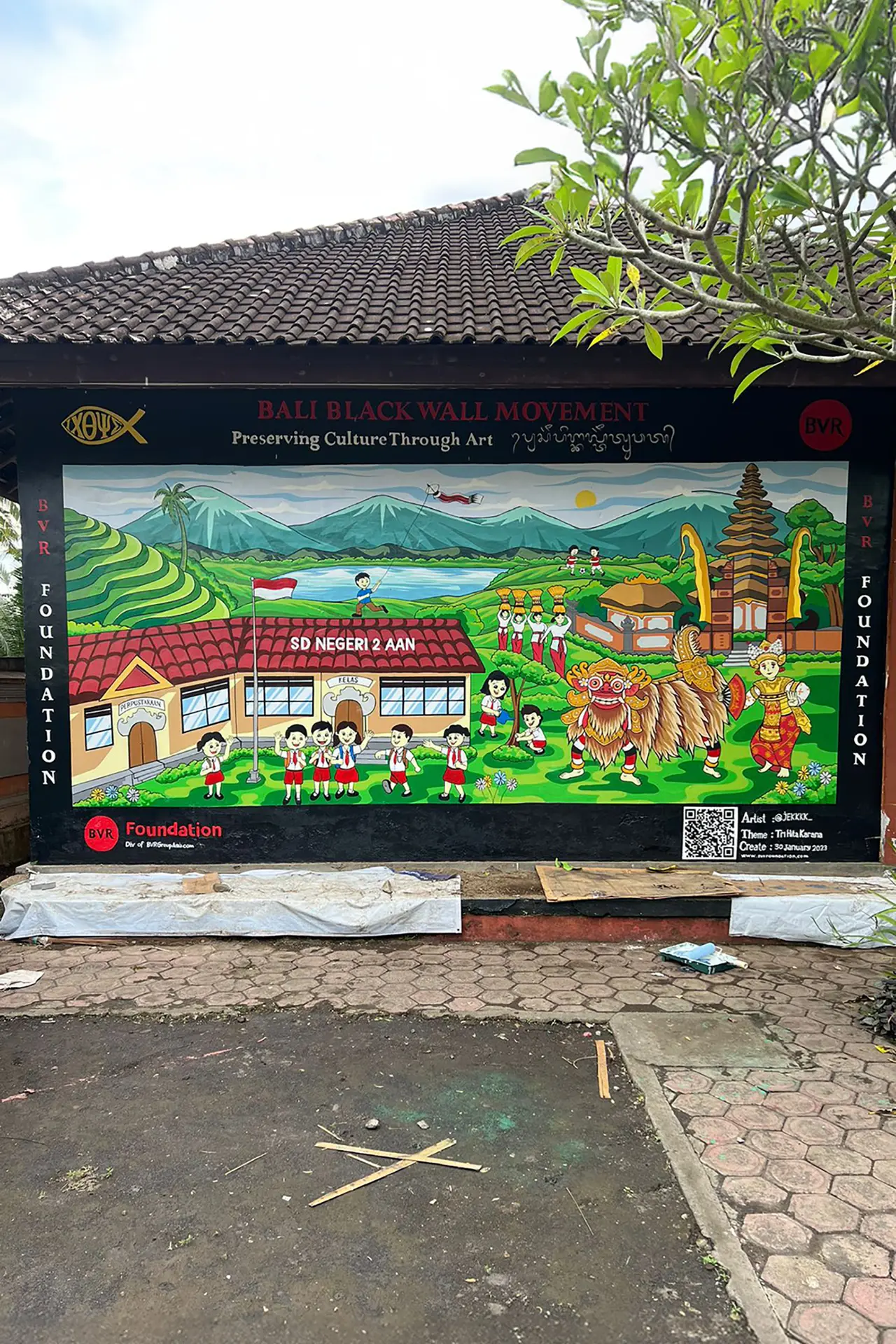 A colorful mural depicting Balinese culture, a temple, and schoolchildren.